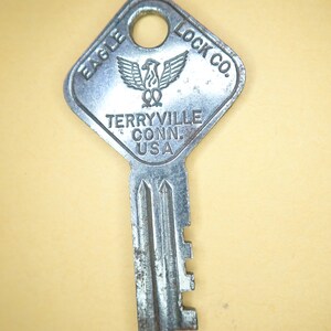 May include: Silver key with a square head that says "Eagle Lock Co. Terryville Conn. USA" and has an eagle design.