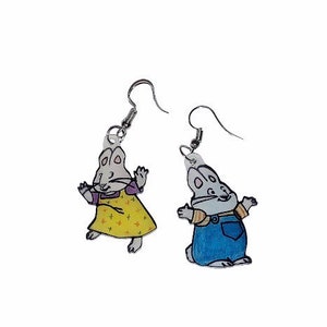 May include: A pair of earrings featuring cartoon characters from the children's book series, 'The  Mouse and the Motorcycle'. The earrings are made of clear acrylic and feature a silver-colored metal hook.