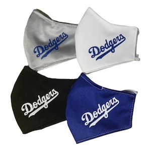 May include: Four face masks in silver, white, black, and blue. Each mask features the word "Dodgers" in a script font. The masks are made of a soft fabric and have ear loops for secure wear.
