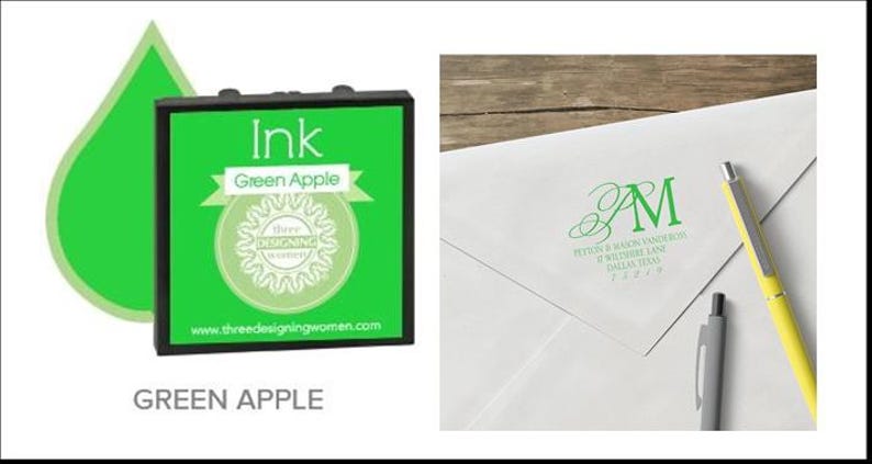 May include: Green apple ink pad with a matching green ink drop graphic. The ink pad is black with a green label that reads "Ink Green Apple" and features a logo. A white envelope with green initials and address is shown with pens.