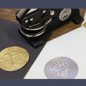 May include: Two round wax seals, one gold and one silver, with different designs. The gold seal has a compass design with the text "You are my north, my south, my east and my west." The silver seal has a decorative design with the text "Alan & Jaime."