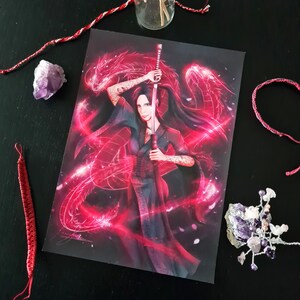 May include: A print featuring a woman holding a sword, with a red dragon design in the background. The woman has tattoos on her arms and is wearing a dark kimono. The artwork has a fantasy theme.