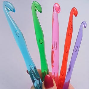 Pu&ograve; includere: Cinque uncinetti di plastica colorati: blu, verde, rosa, rosso e viola.