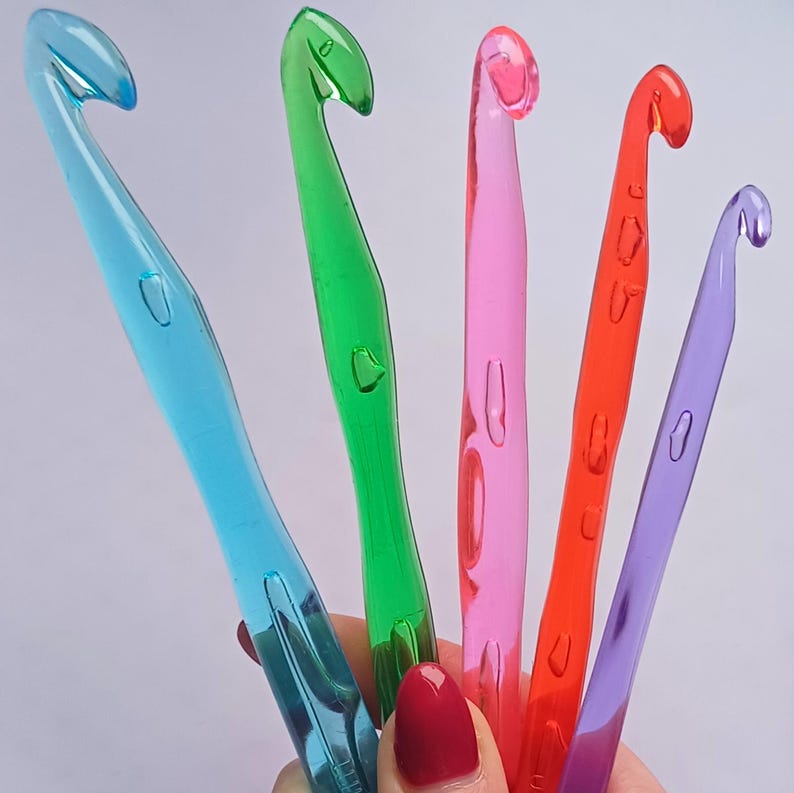 Pu&ograve; includere: Cinque uncinetti di plastica colorati: blu, verde, rosa, rosso e viola.