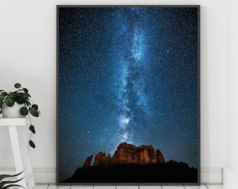 May include: A black framed photograph of a night sky with the Milky Way galaxy visible above a dark silhouette of a mountain range. The image is titled "Erica Fuchs Photography".