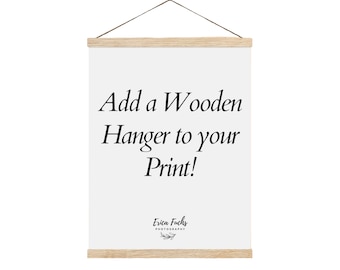 May include: White canvas print with the text "Add a Wooden Hanger to your Print!" and the logo "Erica Fuchs Photography" at the bottom. The print is hanging from a wooden hanger.