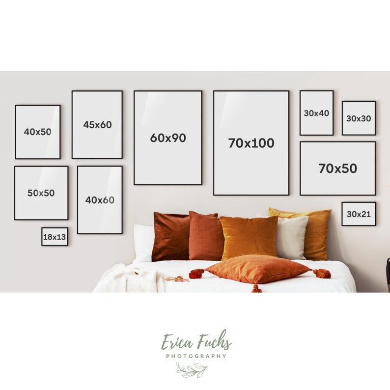 May include: A collection of black framed prints of various sizes hanging on a wall above a bed with orange and brown throw pillows. The prints are labeled with their dimensions in inches, such as 40x50, 60x90, and 70x100.