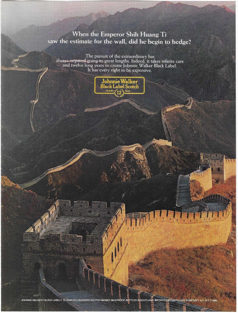 May include: A photograph of the Great Wall of China, a UNESCO World Heritage Site. The wall is made of stone and brick and is winding and long. The text "When the Emperor Shih Huang Ti saw the estimate for the wall, did he begin to hedge?" is at the top of the image. The text "The pursuit of the extraordinary has always required going to great lengths. Indeed, it takes infinite care and twelve long years to create Johnnie Walker Black Label. It has every right to be expensive." is below the image of the wall. The Johnnie Walker Black Label Scotch logo is in the center of the image. The logo is a black and white circle with the text "Johnnie Walker Black Label Scotch" and "YEARS 12 OLD" inside the circle.