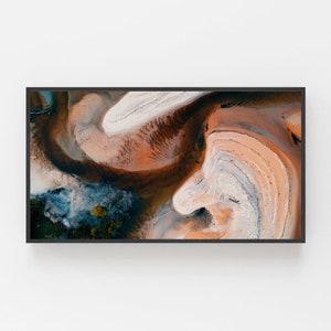 May include: An abstract aerial photograph of a landscape with swirling patterns of orange, brown, white, and blue. The image resembles a painting or a piece of art.
