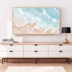 May include: A framed watercolor painting of a beach scene with blue and white waves and a light brown sandy beach.