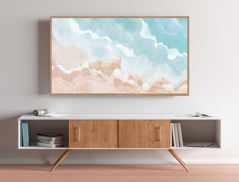 May include: A framed watercolor painting of a beach scene with blue and white waves and a light brown sandy beach.