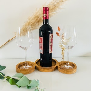 Könnte beinhalten: Serviertablett aus Holz mit drei runden Vertiefungen für Gläser. Eine Flasche Rotwein und zwei Weingläser stehen auf dem Tablett.