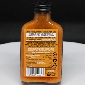 May include: A 100ml bottle of "Ghost Pepper" chili sauce with a red and white vegan label. The bottle is clear and shows the orange sauce inside. The label includes the brand name "Crazy Bastard" and the ingredients and nutritional information.