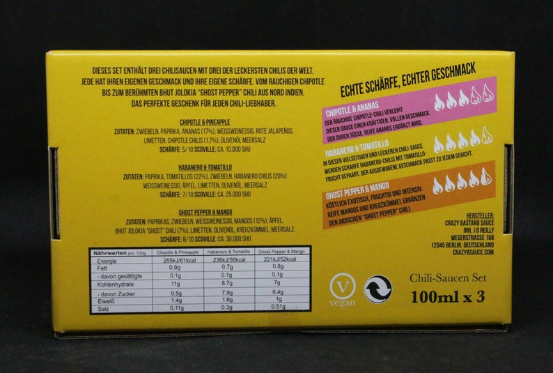 May include: Yellow box with a set of three chili sauces. The sauces are labeled "Chipotle & Pineapple", "Habanero & Tomatillo", and "Ghost Pepper & Mango". The box also includes nutritional information and a vegan symbol.