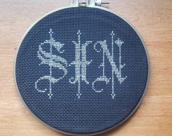 6 inch SIN completed cross stitch - silver thread on black aida wall hanging