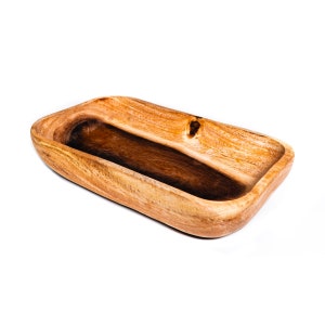 May include: A rectangular wooden bowl with a natural wood grain finish. The bowl has a smooth, curved design with a dark interior and a knot detail on one side. The bowl is empty and sits on a white background.