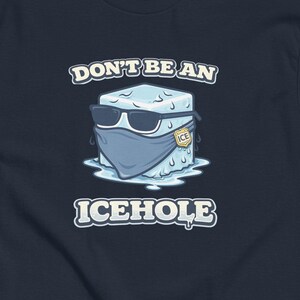 Peut inclure: T-shirt bleu marine avec un dessin d'un glaçon portant des lunettes de soleil et un masque. Le texte sur le t-shirt se lit "DON'T BE AN ICEHOLE."