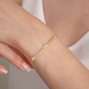 May include: Gold bracelet with the names "Michael & Harper" in cursive script.