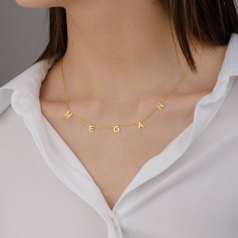 May include: A gold necklace with the name "Megan" spelled out in individual letters.
