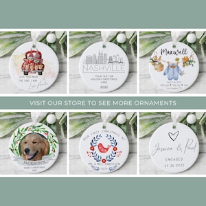 K&ouml;nnte beinhalten: Wei&szlig;e Keramik-Weihnachtsornamente mit verschiedenen Designs und Texten. Eines zeigt ein Zwergenpaar in einem Truck, ein anderes die Skyline von Nashville und ein drittes mit einem Babykleidungsdesign. Weitere Ornamente zeigen ein Hundefoto, einen Kranz mit einem Vogel und ein Herz mit Namen.