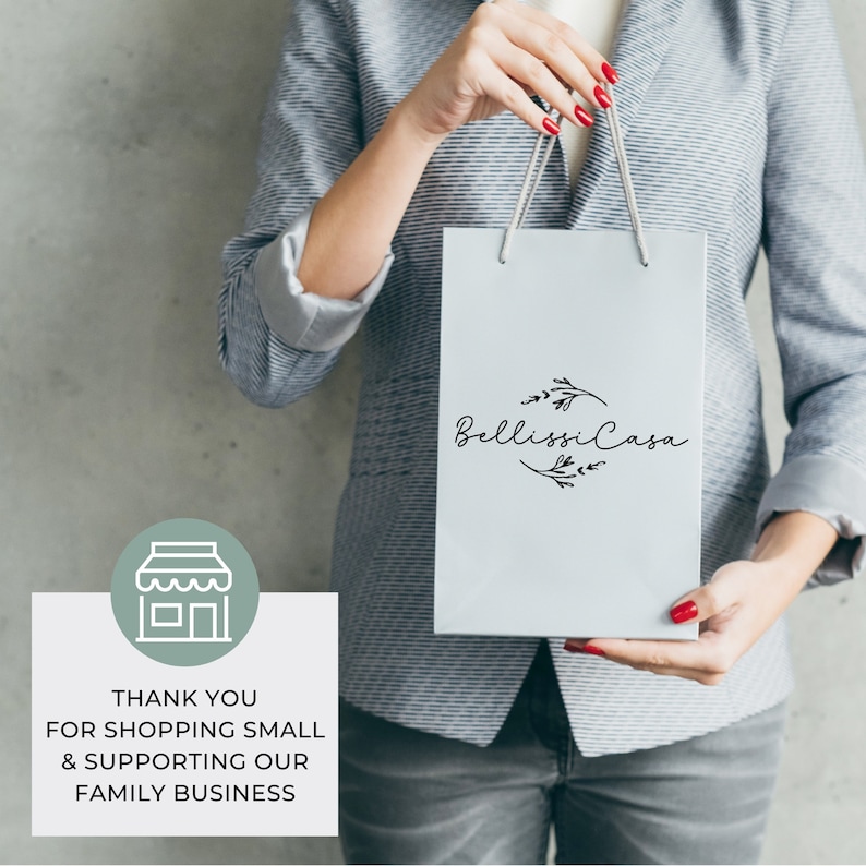 K&ouml;nnte beinhalten: Eine hellgraue Einkaufstasche mit dem Text "Bellissi Casa" in schwarzer Schrift und einem floralen Design. Die Tasche wird von einer Person in einem grauen Blazer gehalten. Das Bild enth&auml;lt auch den Text "THANK YOU FOR SHOPPING SMALL & SUPPORTING OUR FAMILY BUSINESS".
