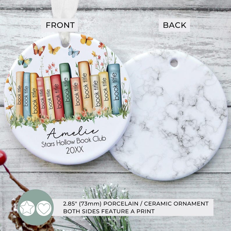 May include: A round porcelain ornament, 2.85 inches (73mm), with a front design featuring a stack of colorful books, butterflies, and flowers. The back has a white marble pattern. Text includes "Amelie", "Stars Hollow Book Club", and "20XX".