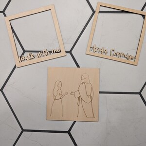 Pode incluir: Dois quadros quadrados de madeira clara e uma placa quadrada de madeira. Um quadro apresenta o texto "Walk with me" e o outro "Anda Conmigo". A placa exibe uma ilustra&ccedil;&atilde;o de linhas de uma pessoa diante de uma figura.