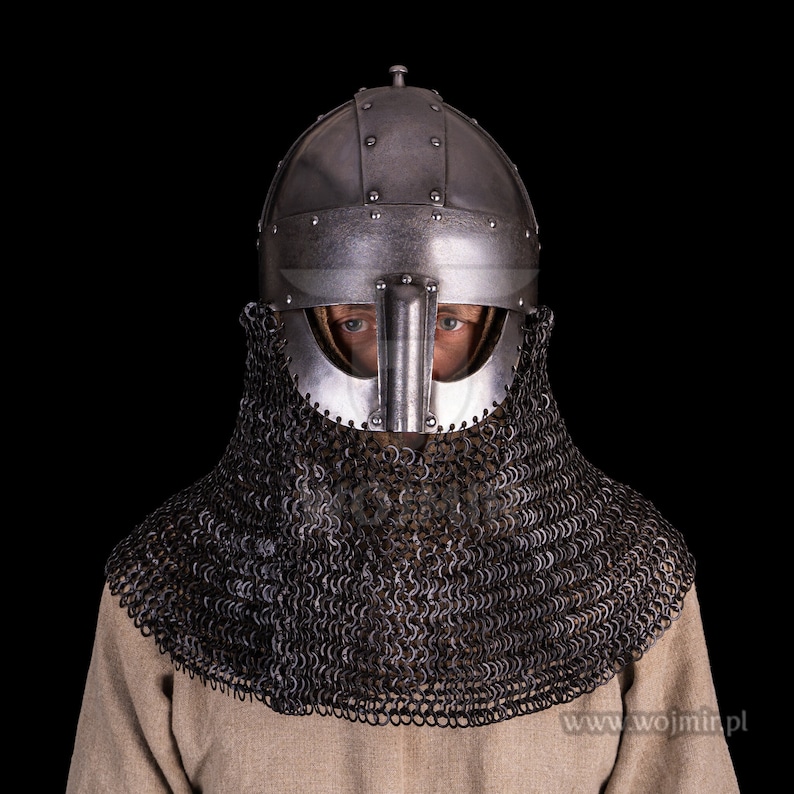 Puede incluir: Un casco medieval con una cota de malla. El casco est&aacute; hecho de metal y tiene una punta puntiaguda. La cota de malla est&aacute; hecha de anillos de metal unidos entre s&iacute;. El casco y la cota de malla son ambos de color plateado.