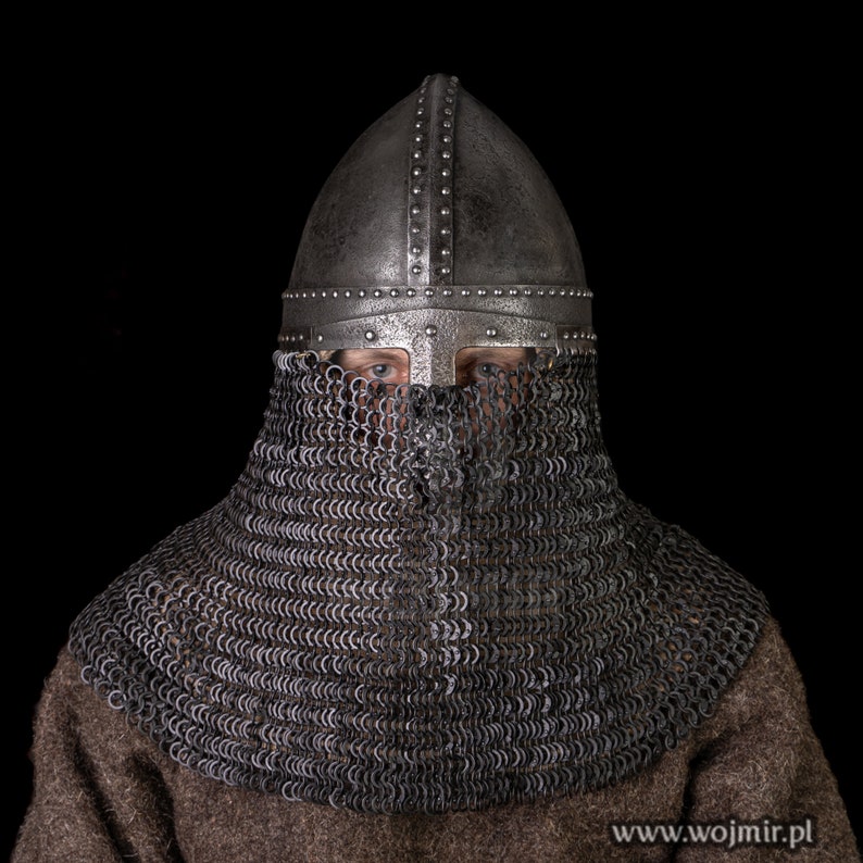 May include: A medieval helmet with a chainmail coif. The helmet is made of metal and has a pointed top. The coif is made of metal rings linked together. The helmet and coif are both silver in color.