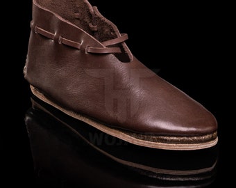 May include: A pair of brown leather shoes with laces. The shoes have a pointed toe and a flat sole.