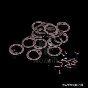 Puede incluir: Un mont&oacute;n de anillos de metal con un peque&ntilde;o agujero en cada anillo. Tambi&eacute;n hay una serie de peque&ntilde;as clavijas de metal esparcidas alrededor de los anillos.