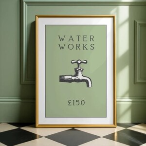 May include: A framed wall art print featuring a sage green background with the black text WATER WORKS above a black and white illustration of a water faucet and the text &pound;150 below, all enclosed in a thin gold frame with a white mat border.