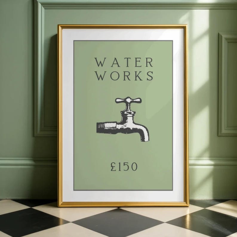 May include: A framed wall art print featuring a sage green background with the black text WATER WORKS above a black and white illustration of a water faucet and the text &pound;150 below, all enclosed in a thin gold frame with a white mat border.
