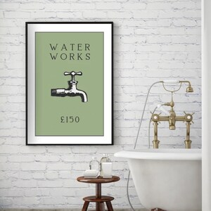 May include: A framed wall art print featuring a sage green background with the black text WATER WORKS, a black and white illustration of a water faucet, and the text &pound;150 centered below the faucet in a simple black serif font.