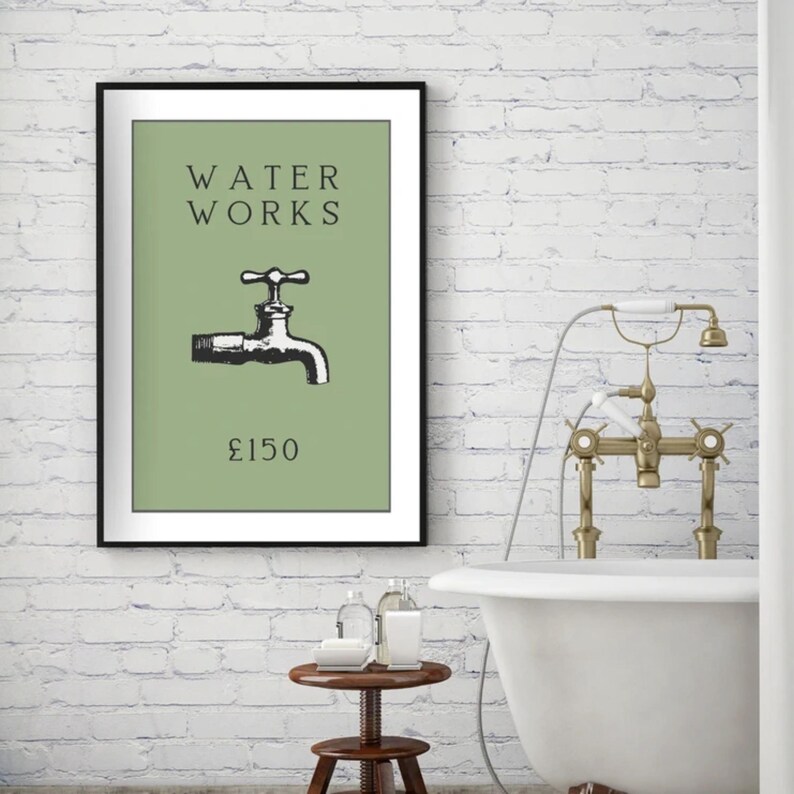 May include: A framed wall art print featuring a sage green background with the black text WATER WORKS, a black and white illustration of a water faucet, and the text &pound;150 centered below the faucet in a simple black serif font.
