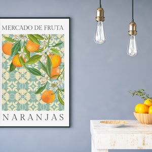 May include: A framed print with a blue and white tiled background featuring a branch of orange blossoms and oranges. The text "MERCADO DE FRUTA" and "NARANJAS" is printed in black at the top and bottom of the print.