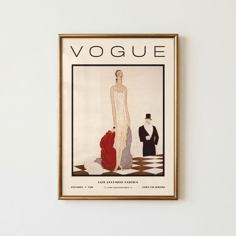 Może przedstawiać: Oprawiony wydruk okładki magazynu Vogue z grudnia 1926 roku zatytułowany Late December Fashion. Ilustracja przedstawia wysoką postać w kremowej sukni z czerwonymi i szarymi akcentami materiału na szachownicowej podłodze obok osoby w smokingu.
