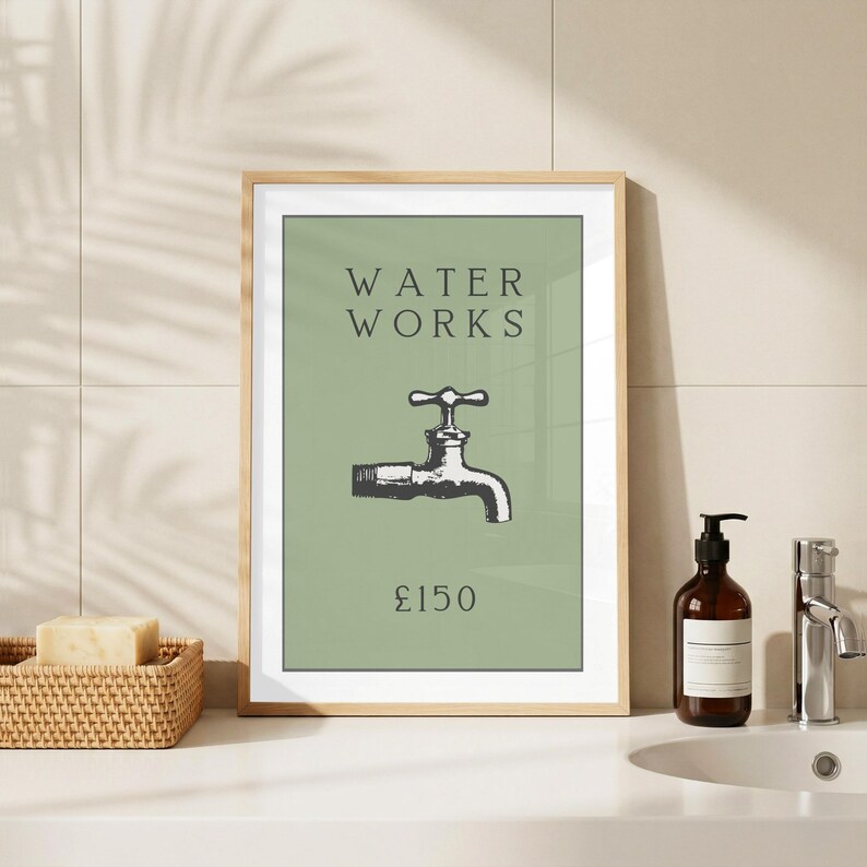May include: A framed wall art print featuring a sage green background with the text WATER WORKS in dark gray, a black and white illustration of a water faucet in the center, and the text &pound;150 printed in dark gray at the bottom of the print.