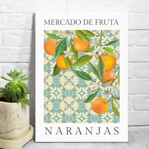 May include: A vintage-style poster with a blue and white tiled background featuring a branch of orange blossoms and oranges. The text "Mercado de Fruta Naranjas" is printed in black at the top and bottom of the poster.