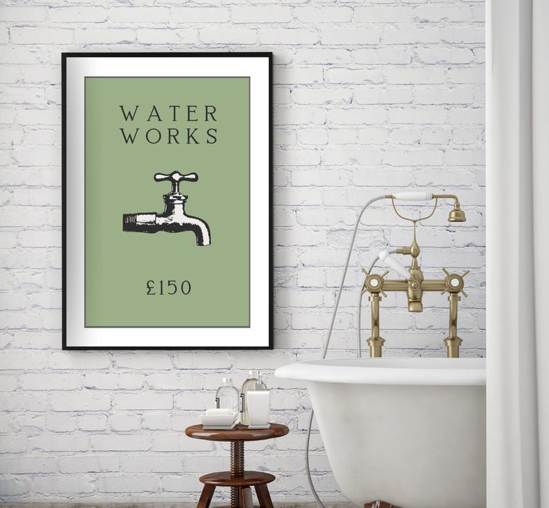 May include: A framed wall art print featuring a sage green background with the black text WATER WORKS, a black illustration of a water faucet, and the text &pound;150 at the bottom. The print is displayed in a thin black frame on a white brick wall.