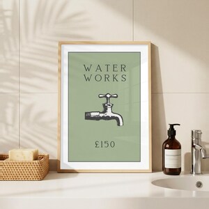 May include: A framed wall art print featuring a sage green background with the text WATER WORKS in dark gray, a black and white illustration of a water faucet in the center, and the text &pound;150 printed in dark gray at the bottom of the print.