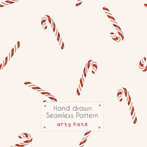 May include: A seamless pattern featuring watercolor candy canes with red and white diagonal stripes on a cream background. A white rectangular label with scalloped edges contains the text: Hand drawn Seamless Pattern arty kate.