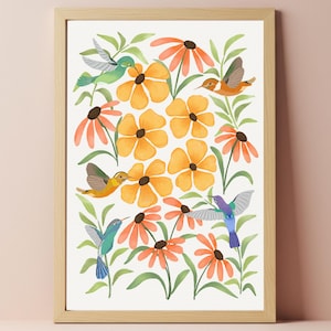 Può includere: Una stampa ad acquerello incorniciata con un vivace design floreale con fiori arancioni e gialli, foglie verdi e diversi colibrì in volo. L'opera d'arte è incorniciata in una cornice di legno marrone chiaro.