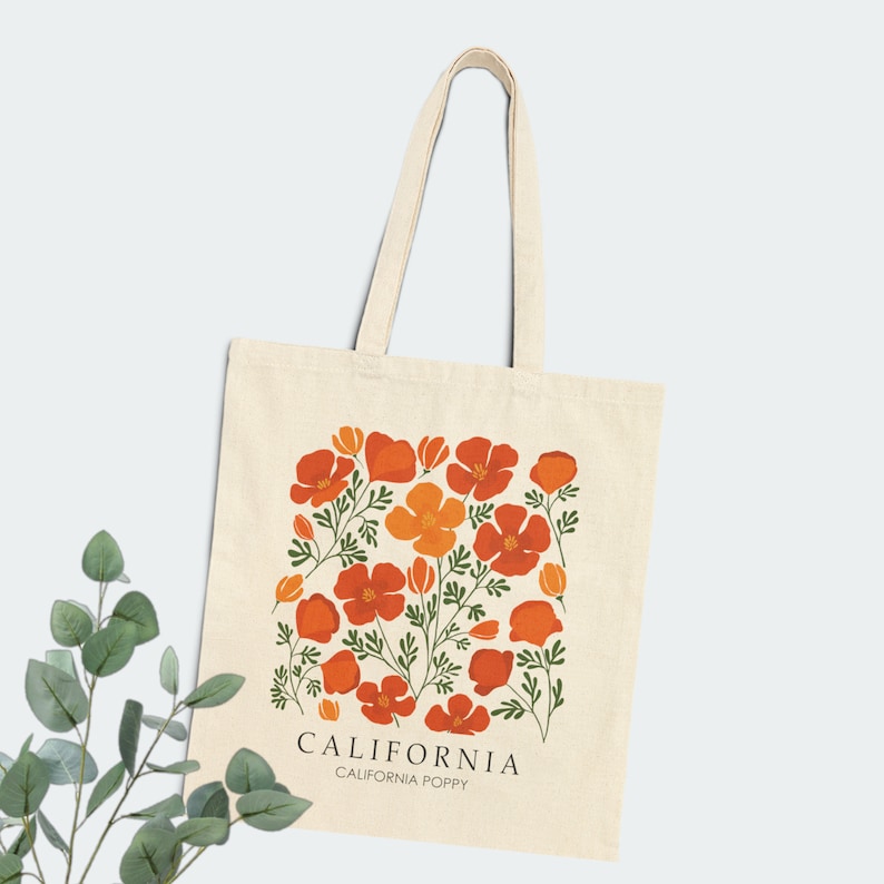 May include: A beige tote bag with a design of orange and red California poppies. The text "CALIFORNIA" and "CALIFORNIA POPPY" is printed on the bag.