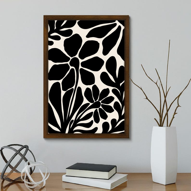 May include: Black and white floral print framed wall art with a brown frame. The print features stylized flowers and leaves.