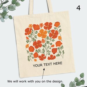 May include: A beige tote bag with a floral design featuring orange and red poppy flowers. The bag has a white text overlay that says "YOUR TEXT HERE".