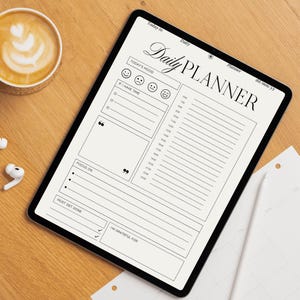 Op de afbeelding: Een digitale dagplanner weergegeven op een tablet. De planner heeft secties voor stemming, taken en dankbaarheid. De tekst "Daily Planner" staat bovenaan. Een kopje koffie en oortelefoons liggen op het houten oppervlak.