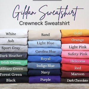 May include: A display of Gildan crewneck sweatshirts in various colors, including white, ash, sport gray, dark heather, and black. Other colors include Irish green, military green, forest green, sand, light blue, and Carolina blue.