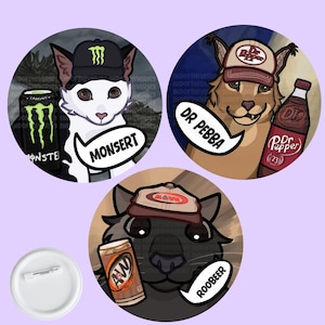 Puede incluir: Tres chapas circulares con ilustraciones de animales que llevan gorras con temática de bebidas y bocadillos de texto. Uno muestra un gato blanco con gorra Monster y lata MONSERT, un lince con gorra Dr. Pepper y botella DR PEBBA, y un gato negro con gorra A&W y lata ROOBEER.