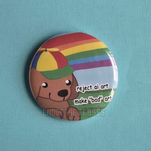 May include: A circular pinback button featuring a brown cartoon dog wearing a multi-colored cap. The background shows a rainbow over a green field. The text reads: reject ai art, make "bad" art. The design has a glossy finish and vibrant colors.